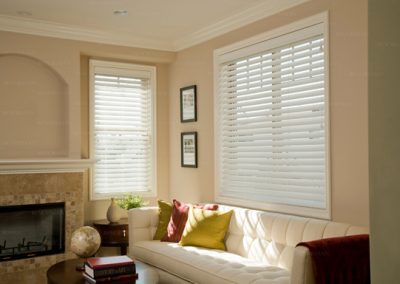 Sunlit living room with white sofa and blinds