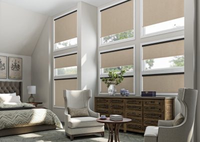 Sunlit bedroom with beige roller shades