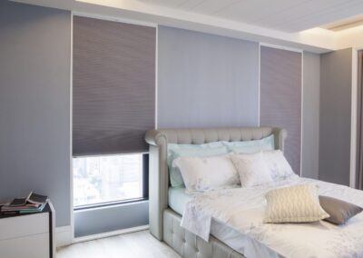 Modern bedroom with tufted bed and grey blinds