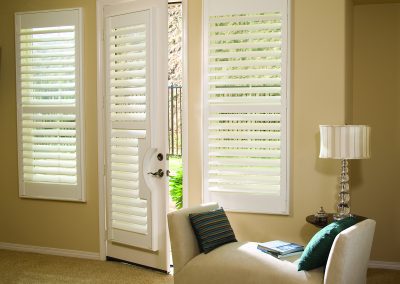 Living room chaise by white plantation shutters