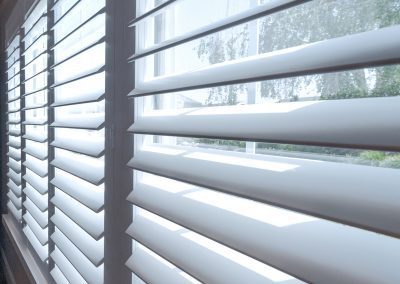 White plantation shutters with sunlight filtering