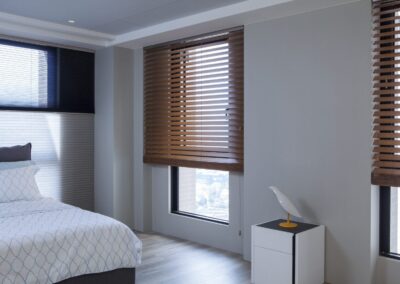 Minimal modern bedroom with wooden blinds and bedding