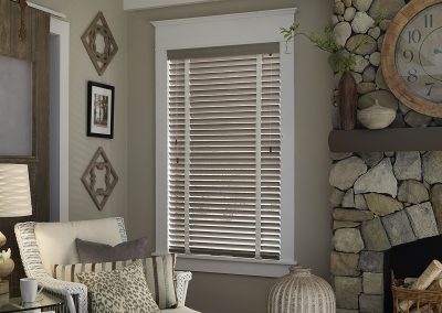 Cozy living room with blinds and stone fireplace