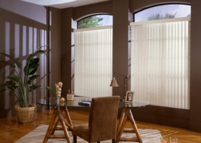 Home office with glass desk and vertical blinds